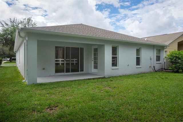 rear view of property with a lawn and a patio area