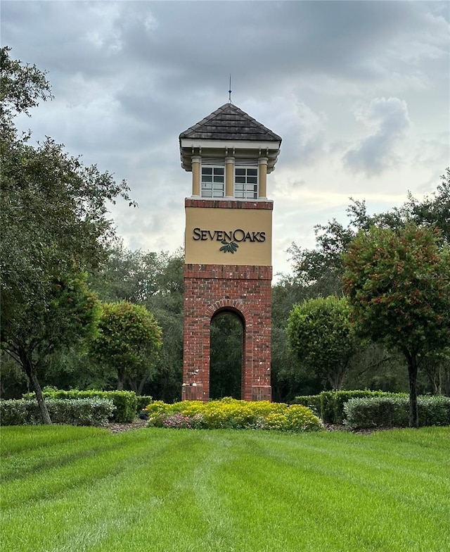 community / neighborhood sign featuring a yard