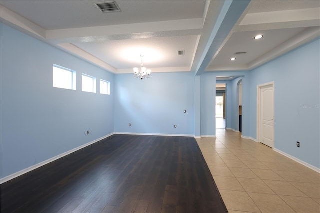 unfurnished room featuring hardwood / wood-style floors and a notable chandelier