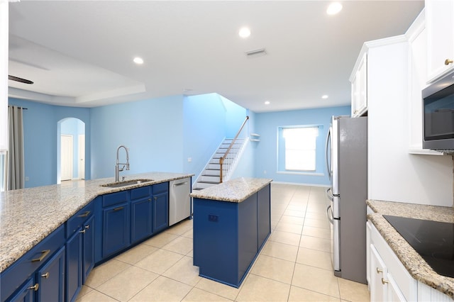 kitchen with a center island, white cabinets, stainless steel appliances, and sink