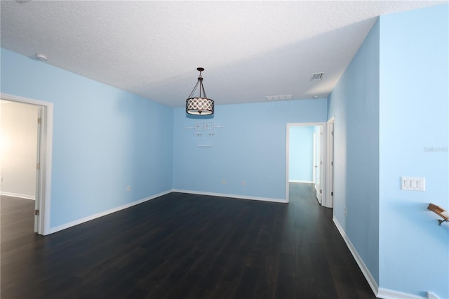 unfurnished dining area featuring dark wood-type flooring and a textured ceiling