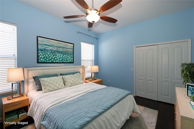 bedroom with hardwood / wood-style floors, ceiling fan, and a closet