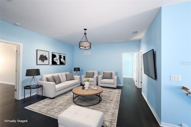 living room featuring a textured ceiling and dark hardwood / wood-style floors