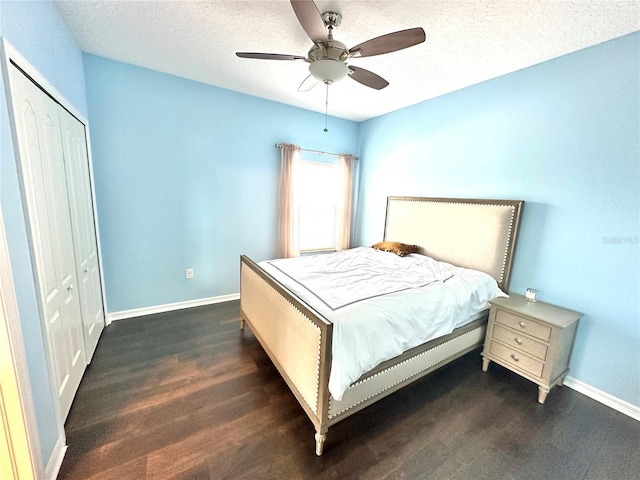 bedroom with a textured ceiling, dark hardwood / wood-style flooring, a closet, and ceiling fan