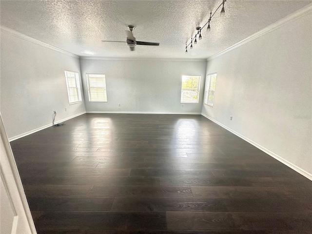 empty room with dark hardwood / wood-style flooring, ornamental molding, a textured ceiling, and track lighting