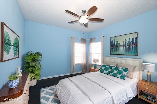 bedroom featuring ceiling fan, dark hardwood / wood-style flooring, and a textured ceiling