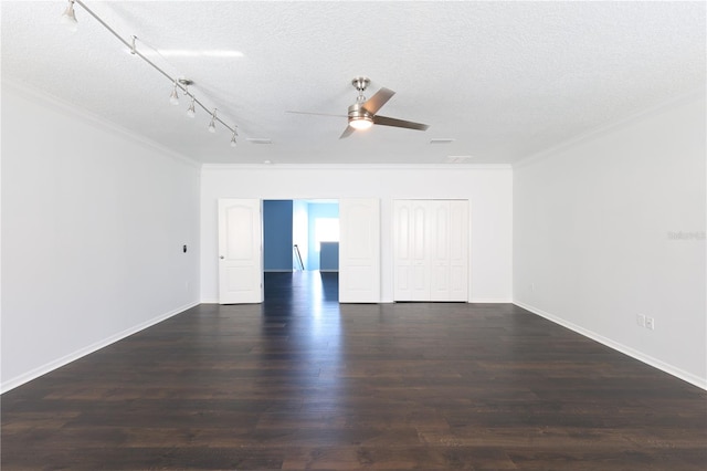 empty room with a textured ceiling, crown molding, and dark wood-type flooring