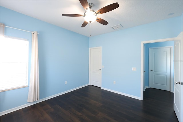 spare room featuring dark hardwood / wood-style floors, ceiling fan, and a textured ceiling