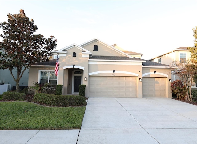 view of front of property with a garage, concrete driveway, and stucco siding