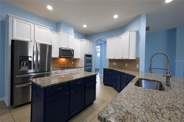 kitchen with appliances with stainless steel finishes, white cabinetry, blue cabinets, and sink