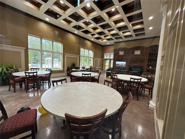 dining area featuring beamed ceiling, a towering ceiling, and coffered ceiling