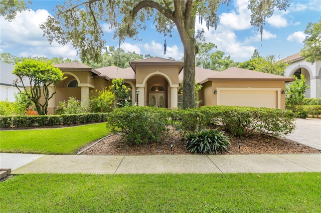 mediterranean / spanish home with a front yard and a garage