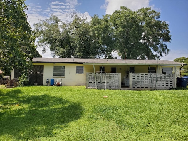 back of property featuring a lawn