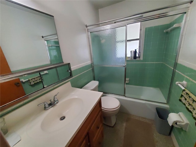 full bathroom featuring vanity, shower / bath combination with glass door, and toilet