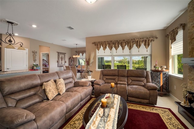 living room featuring light tile patterned flooring, a chandelier, and a fireplace