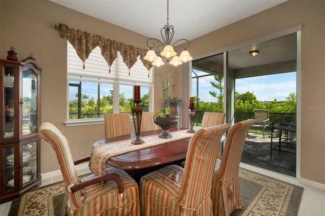 tiled dining room with an inviting chandelier