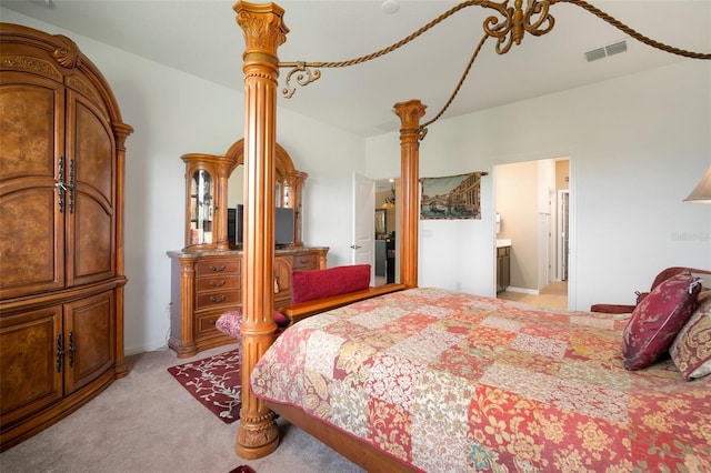 bedroom featuring light carpet and connected bathroom