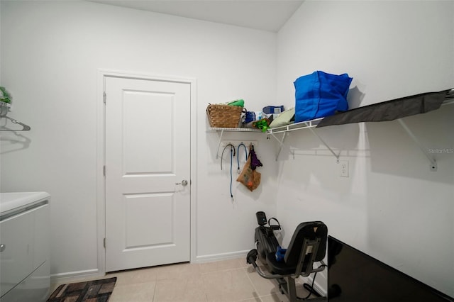 clothes washing area with light tile patterned floors