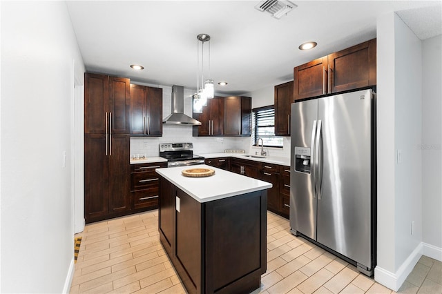 kitchen featuring a center island, hanging light fixtures, stainless steel appliances, dark brown cabinetry, and wall chimney exhaust hood