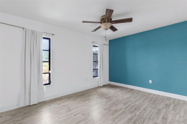 spare room with light hardwood / wood-style flooring, ceiling fan, and plenty of natural light