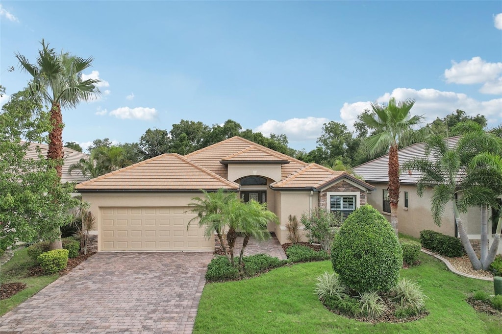 mediterranean / spanish-style house featuring a front lawn and a garage