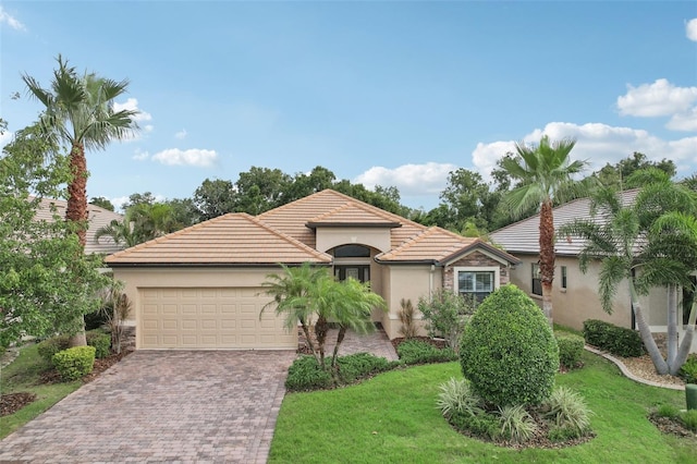 mediterranean / spanish-style house featuring a front lawn and a garage