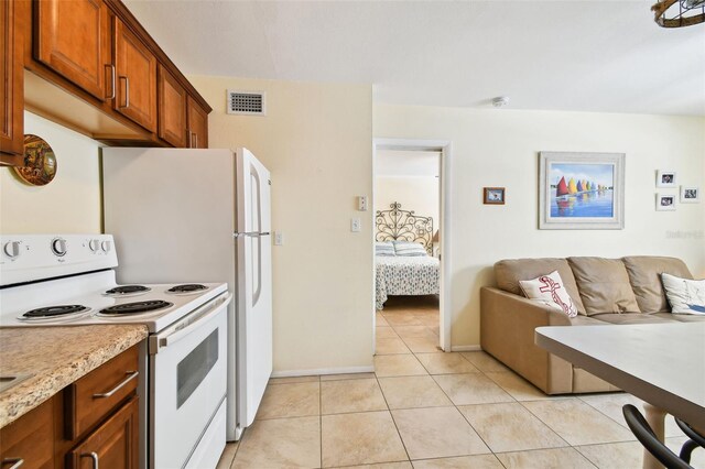 kitchen featuring white electric range and light tile patterned flooring