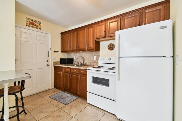 kitchen with decorative backsplash, sink, white appliances, and light tile patterned floors