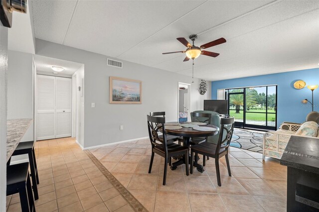 tiled dining space featuring ceiling fan