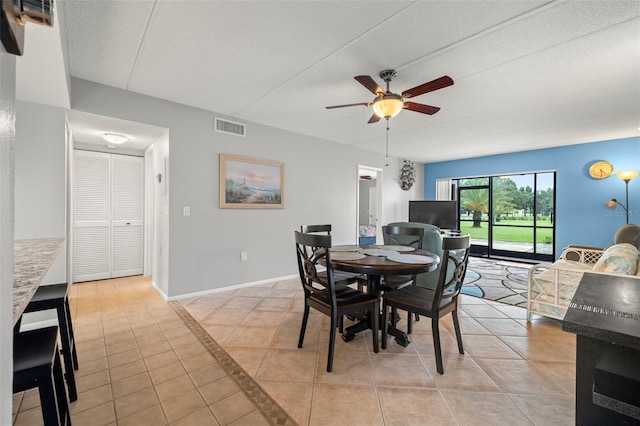 dining room featuring light tile patterned floors, baseboards, visible vents, a ceiling fan, and a textured ceiling