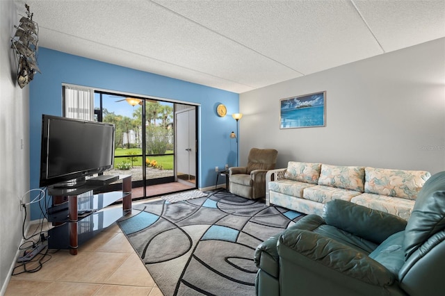 living area with baseboards, a textured ceiling, and light tile patterned flooring