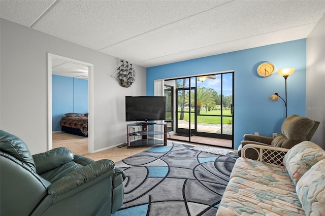 living area featuring light tile patterned floors, baseboards, and a textured ceiling