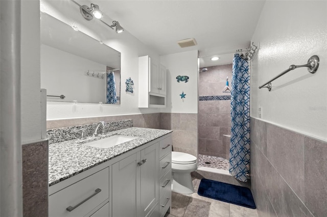 full bathroom with toilet, a stall shower, tile walls, and vanity