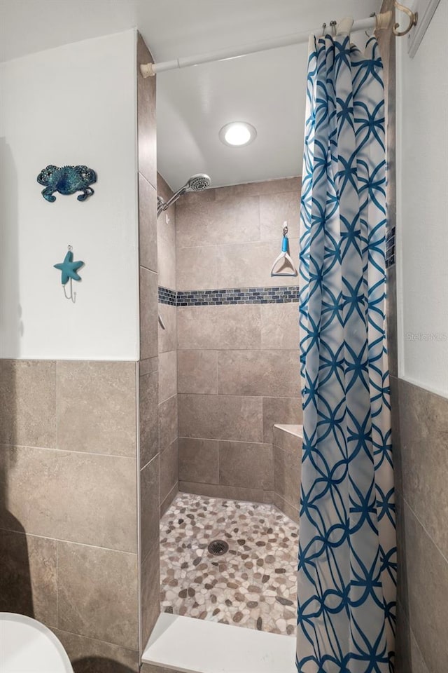 bathroom featuring a tile shower and tile walls