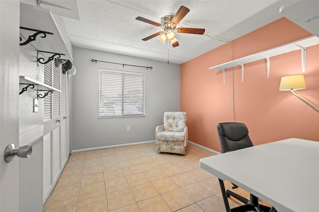 office area featuring a textured ceiling, ceiling fan, light tile patterned floors, and baseboards