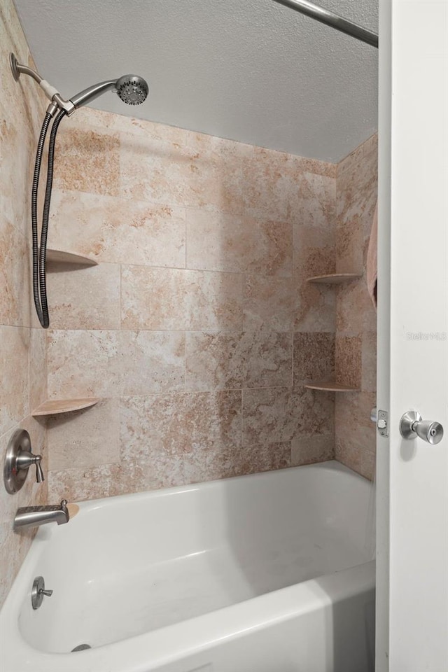 full bathroom with shower / washtub combination and a textured ceiling