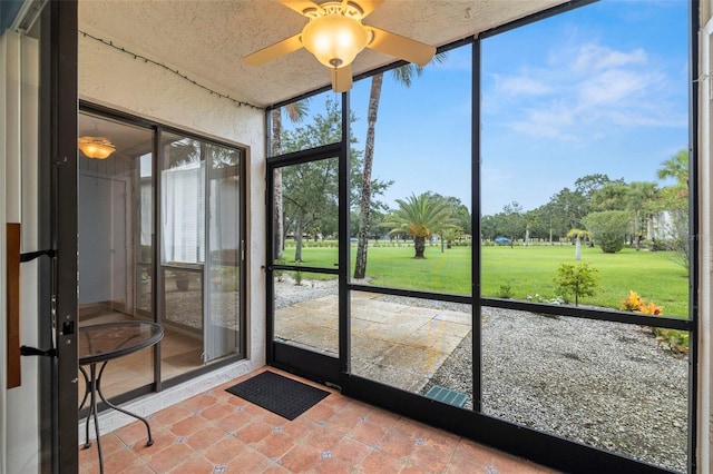 unfurnished sunroom with ceiling fan