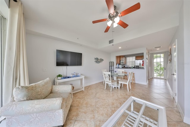 living room featuring light tile patterned floors and ceiling fan