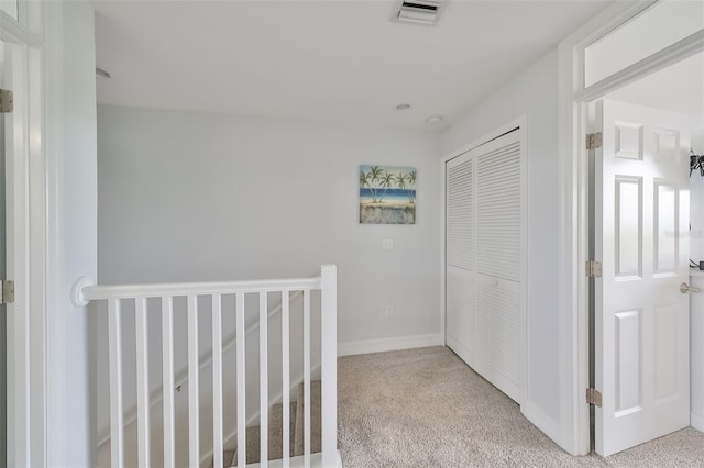 hall with light colored carpet