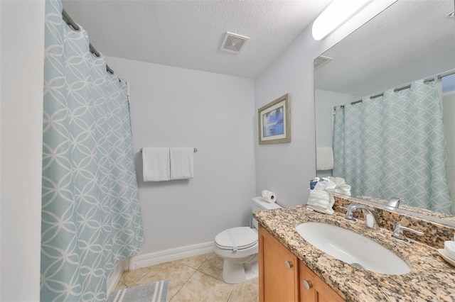 bathroom featuring tile patterned flooring, vanity, toilet, and a textured ceiling