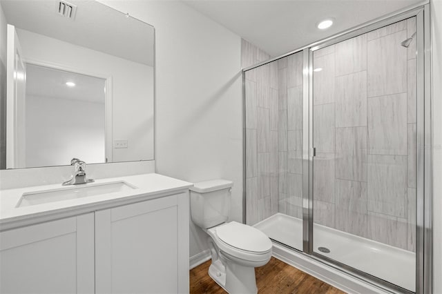 bathroom featuring vanity, wood-type flooring, toilet, and walk in shower