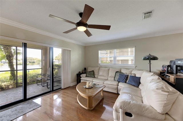 living room featuring a wealth of natural light, wood-type flooring, crown molding, and ceiling fan