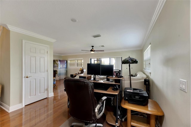 office space with visible vents, ornamental molding, ceiling fan, wood finished floors, and baseboards