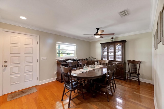 dining room with ceiling fan, crown molding, and light wood-type flooring