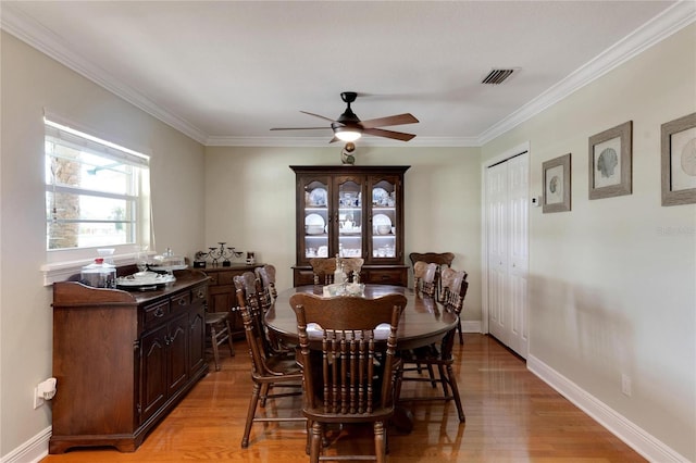 dining area with light wood-type flooring, ornamental molding, and ceiling fan