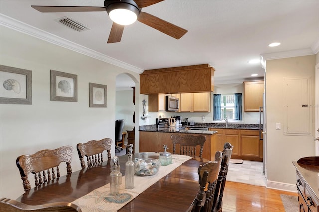 dining space featuring sink, ceiling fan, light tile patterned floors, and crown molding