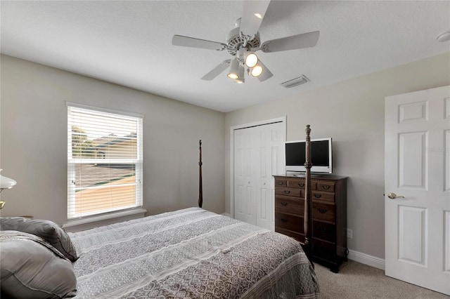 bedroom with light carpet, a ceiling fan, visible vents, baseboards, and a closet