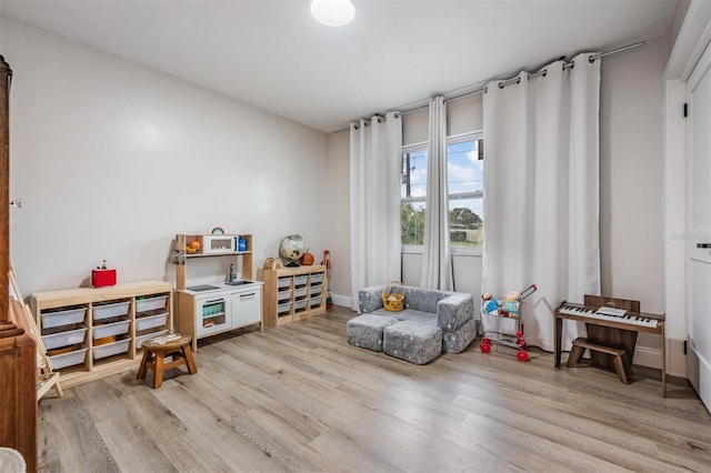 game room with light hardwood / wood-style flooring