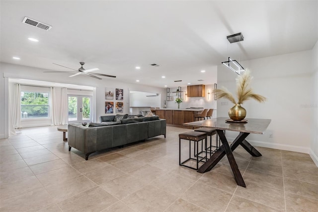 tiled living room featuring french doors and ceiling fan