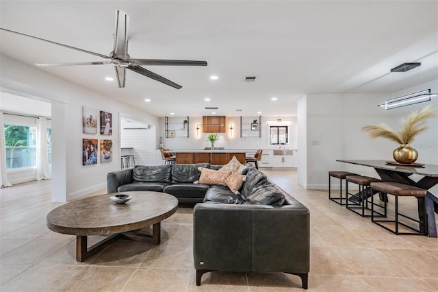 tiled living room with ceiling fan and a wall mounted AC